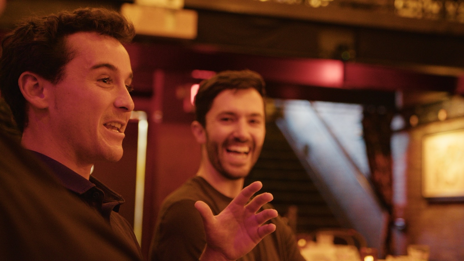 Two teammates laughing at the bar