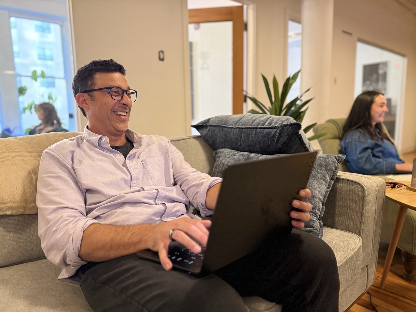 Christopher on the office couch, laptop open