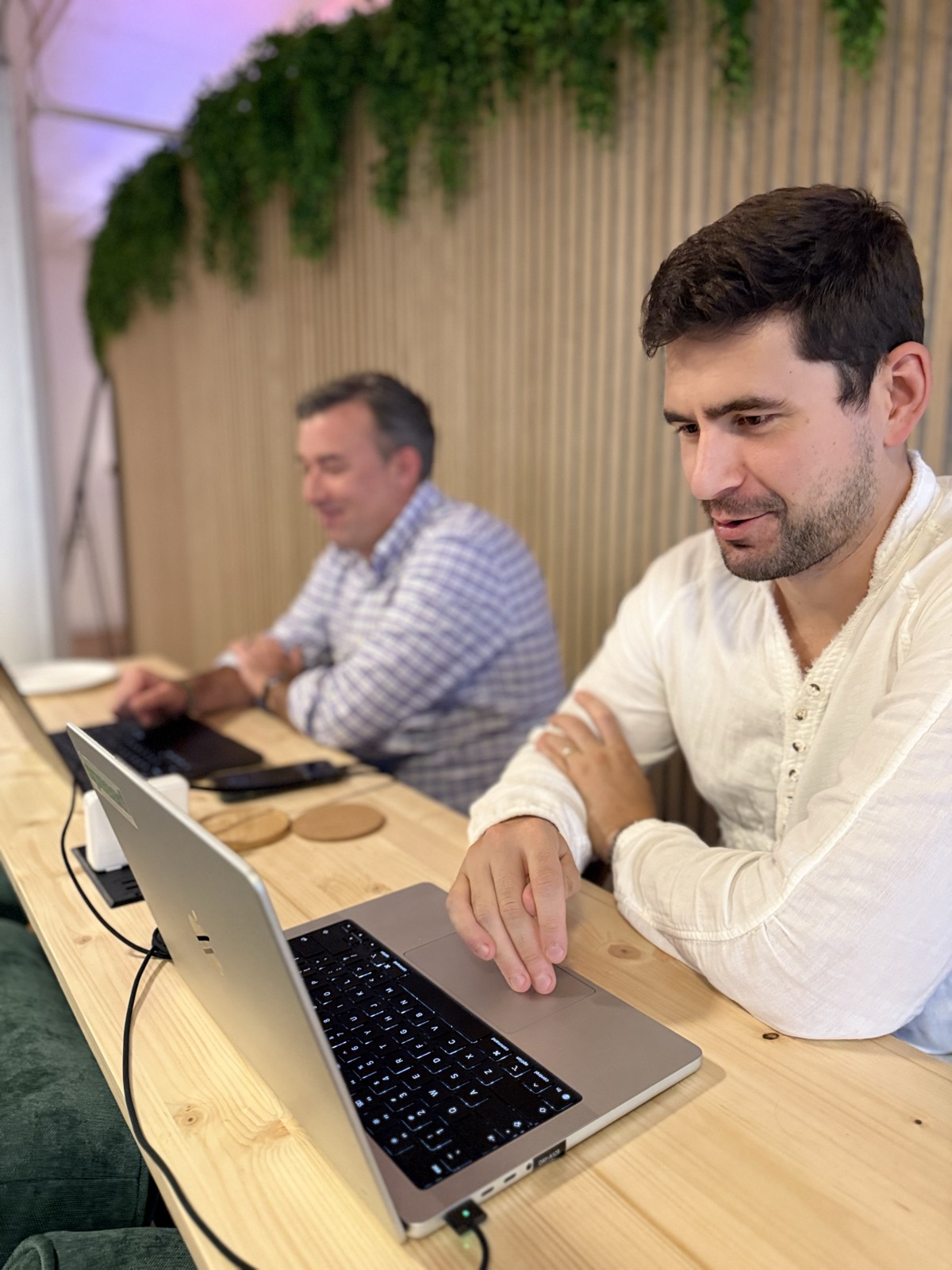 Two teammates working at the desk bar
